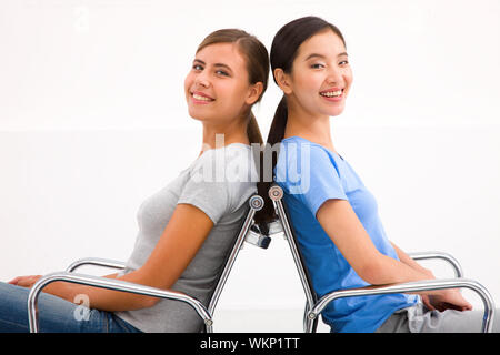 Deux happy businesswoman sitting dans des chaises à l'arrière Banque D'Images