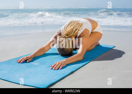 Superbe blonde fit childs posent sur la plage par une journée ensoleillée Banque D'Images