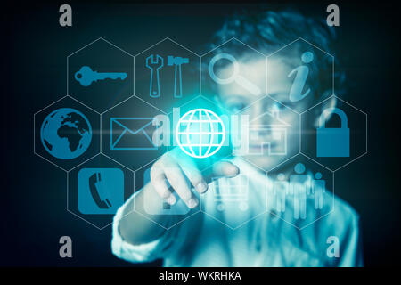 Enfant appui sur le bouton bleu avec le world wide web icône sur un écran virtuel. Photographie montrant les concepts de l'utilisation de la technologie et internet Banque D'Images