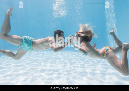 Cute couple kissing sous l'eau dans la piscine sur leurs vacances Banque D'Images