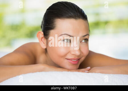 Smiling brunette allongé sur la table de massage au spa Banque D'Images