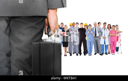 Composite image of businessman holding briefcase contre groupe de travailleurs Banque D'Images
