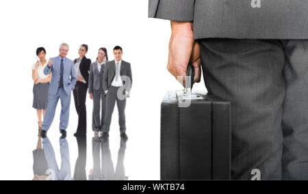 Composite image of businessman holding briefcase contre groupe de gens d'affaires Banque D'Images