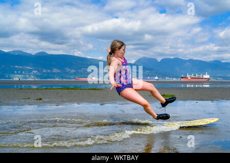 Jeune fille skimboarding, les banques espagnoles, English Bay, Vancouver, British Columbia, Canada Banque D'Images