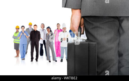 Composite image of businessman holding briefcase contre groupe de travailleurs Banque D'Images