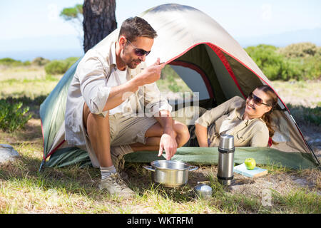 Couple de plein sur la cuisine cuisinière camping tente l'extérieur sur une journée ensoleillée Banque D'Images