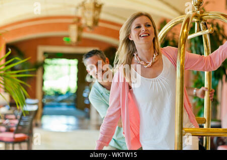 Smiling couple jouant sur un chariot à bagages. Banque D'Images