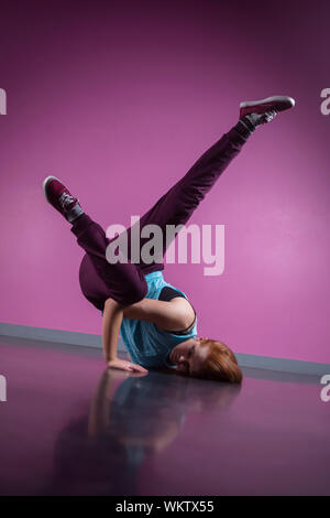 Joli break dancer busting un pas dans le studio de danse Banque D'Images