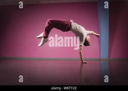 Pause fraîcheur dancer doing handstand sur une main dans le studio de danse Banque D'Images