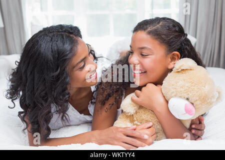 Pretty woman lying on bed with her daughter in à la maison dans la chambre Banque D'Images