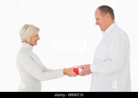 Femme blonde passant cadeau à son partenaire sur fond blanc Banque D'Images