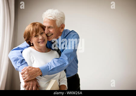 Smiling senior homme embrasse sa femme. Banque D'Images