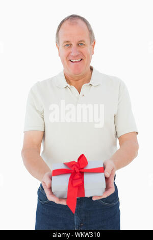 Man smiling at camera holding gift sur fond blanc Banque D'Images