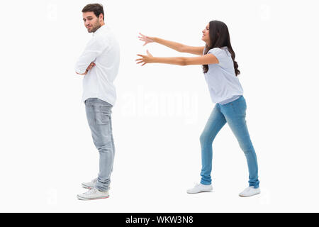 Brunette atteindre désespérément homme sur fond blanc Banque D'Images