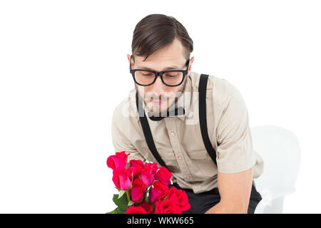 Geeky navré hipster holding roses sur fond blanc Banque D'Images