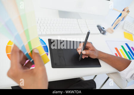 Designer travaillant au bureau à l'aide d'échantillon de couleur et de la tablette dans son bureau Banque D'Images