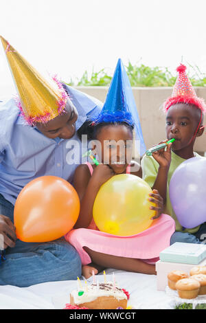 Le père et les enfants fêter un anniversaire ensemble sur une journée ensoleillée Banque D'Images