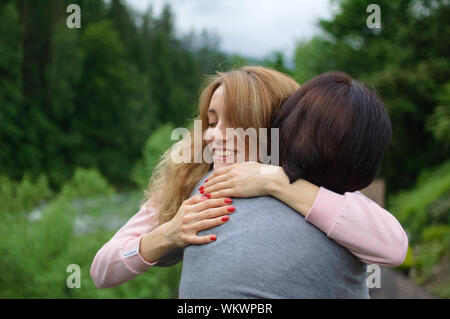 Jeune femme blonde est l'étreindre mère senior bénéficiant d'être ensemble dans les montagnes pendant les vacances. Concept de la tendresse, les soins, l'amour familial Banque D'Images