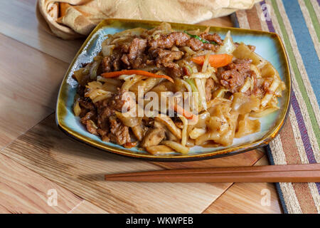 Sauté de boeuf chinois chow fun avec hor fun nouilles de riz larges le chou et les carottes Banque D'Images