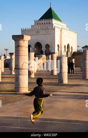 Enfant jouant en face de Mausolée de Mohammed V Banque D'Images