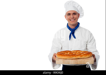 Jeune chef holding une miche de pain frais Banque D'Images