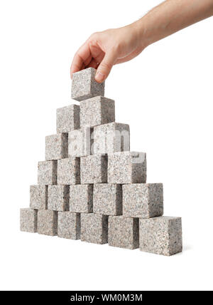 Homme monter en pyramide faite de petits blocs de roche de granit. Banque D'Images