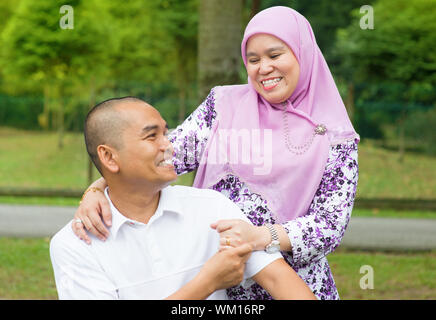 Middle aged couple musulmane de l'Asie du Sud-Est à l'extérieur parc, vie de famille heureuse. Banque D'Images