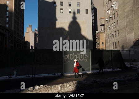 Une femme marche sur Broadway, près de la 28e Rue sur un froid matin de la semaine. L'ombre de l'hôtel nomade est vu dans l'arrière-plan. Banque D'Images