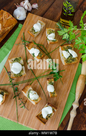 Toasts avec de la mozzarella, de l'huile d'olive, d'herbes et d'ail - thym, origan, persil et ciboulette Banque D'Images