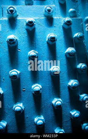 Blue metal wall avec plusieurs gros boulons Banque D'Images