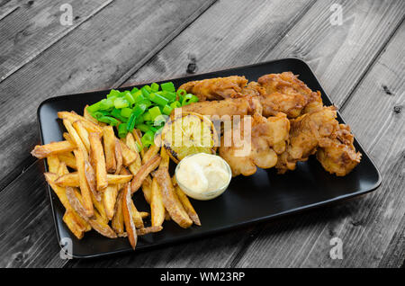 Poisson-frites avec mayonnaise maison sur la plaque noire Banque D'Images