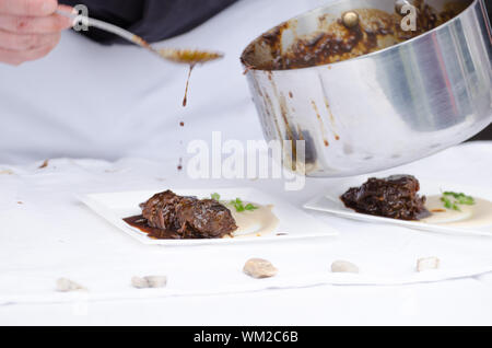 Joues de boeuf braisé à la bière avec purée de céleri-rave avec wasabi, gingembre mousse - chef preparing Banque D'Images