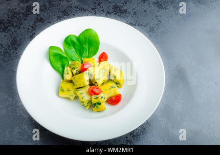 Gnocchi aux épinards avec du beurre fondu et les tomates cerise du jardin Banque D'Images