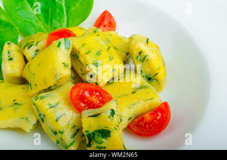 Gnocchi aux épinards avec du beurre fondu et les tomates cerise du jardin Banque D'Images