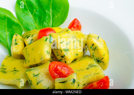 Gnocchi aux épinards avec du beurre fondu et les tomates cerise du jardin Banque D'Images