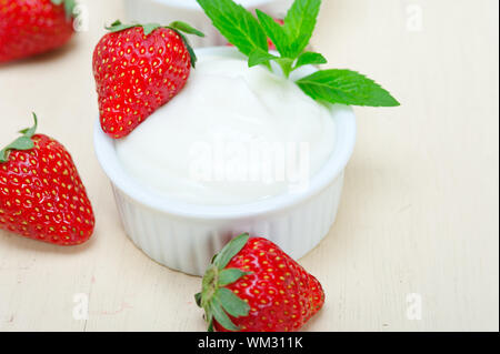 Yaourt à la Grecque biologique et de fraise sur la table rustique en bois blanc Banque D'Images