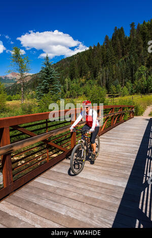 Vélo de montagne traversant un pont sur le sentier Galloping Goose, Uncompahgre National Forest, Colorado USA (MR) Banque D'Images