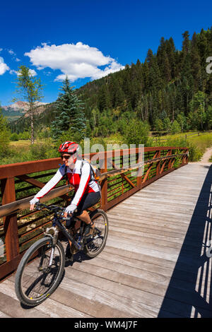 Vélo de montagne traversant un pont sur le sentier Galloping Goose, Uncompahgre National Forest, Colorado USA (MR) Banque D'Images