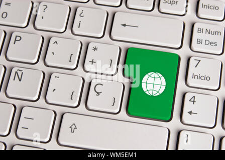 Clavier espagnol avec global eco friendly world icône sur fond vert bouton. Image avec chemin de détourage pour changement facile la couleur clé et l'édition. Banque D'Images