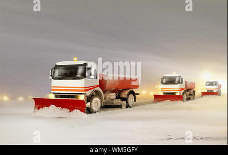 Les camions de déneigement de retirer la neige à partir de l'autoroute pendant une tempête de neige froide journée d'hiver Banque D'Images