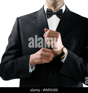 Mains de l'homme qui dans un smoking noir met sur sa montre Banque D'Images