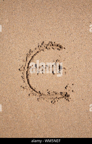 Symbole Euro écrit sur du sable brun rez-de marée basse mer océan plage en Espagne Europe Banque D'Images