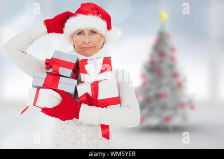 Cadeaux fête femme tenant contre l'arbre de Noël floue dans la chambre Banque D'Images