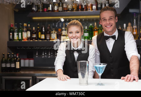 Collègues souriant à la caméra dans un bar Banque D'Images