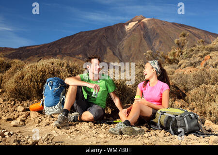 Les gens de la randonnée. Jeune beau couple en faisant une pause, se détendre et manger pendant une randonnée / randonnée dans la belle et sauvage les paysag Banque D'Images