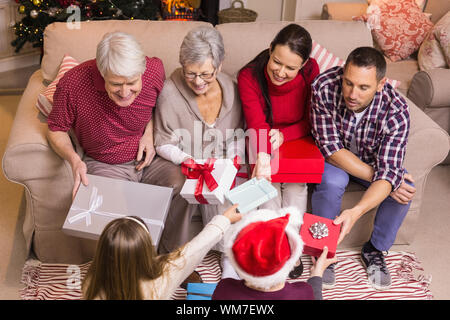 Famille heureuse l'échange de cadeaux à Noël à la maison dans le salon Banque D'Images