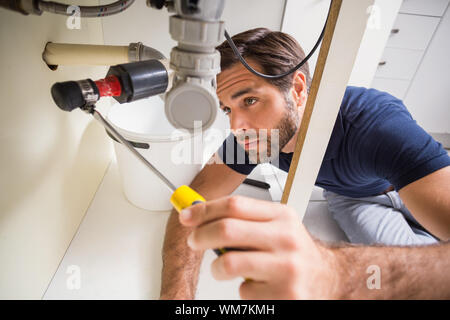 Fixation plombier sous le lavabo dans la cuisine Banque D'Images