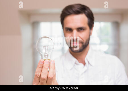 Montrant l'homme à l'appareil photo de l'ampoule à la maison dans le salon Banque D'Images