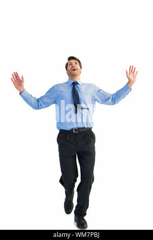 Happy businessman running with hands up on white background Banque D'Images