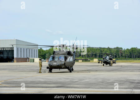 La Garde nationale de Caroline du Sud se félicite UH-60 Black Hawk et d'équipages de l'ouest de la Virginie et de la Garde nationale du Kentucky à McEntire Joint National Guard Base à Eastover, Caroline du Sud, le 4 septembre 2019, en prévision de l'ouragan d'intervention en Caroline du Sud dans le cadre de l'Emergency Management Assistance Compact. La Garde nationale de la Virginie de l'Ouest ont fourni deux UH-60 Black Hawk et huit membres du service dans le cadre de leur hélicoptère de sauvetage aquatique et de l'équipe de la Garde nationale du Kentucky a fourni deux UH-60 Black Hawk et six membres d'offrir des services de soutien à l'aviation générale. Les équipes sont Banque D'Images